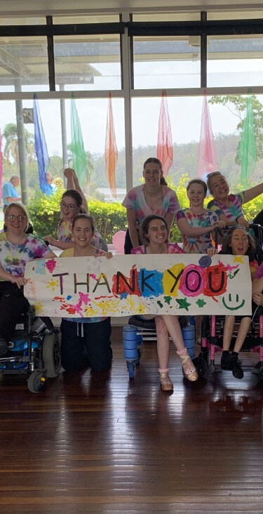 The amazing students from All Abilities Australia Holiday program in January 2020 are all posing happily holoding a big painted thank you sign.